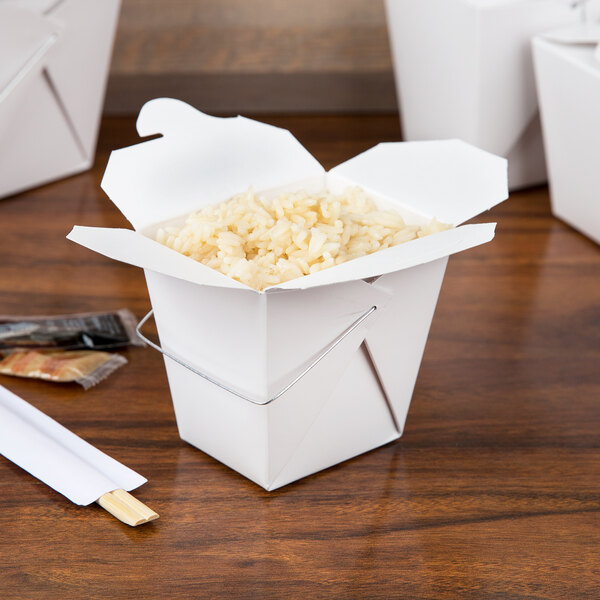 A white Fold-Pak Chinese take-out container with rice and chopsticks.