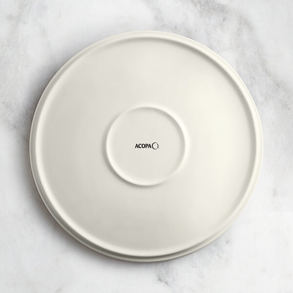 An Acopa Cape beige porcelain plate with black text that says "Oma" on it.