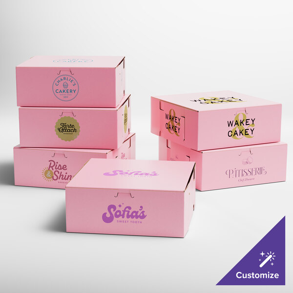 A set of pink bakery boxes with various custom logos and designs printed on them.