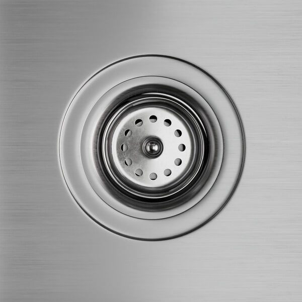 A close-up of a stainless steel sink drain on a Regency hand sink.