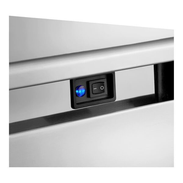A close-up view of the control switch panel on a stainless steel undercounter ice machine.
