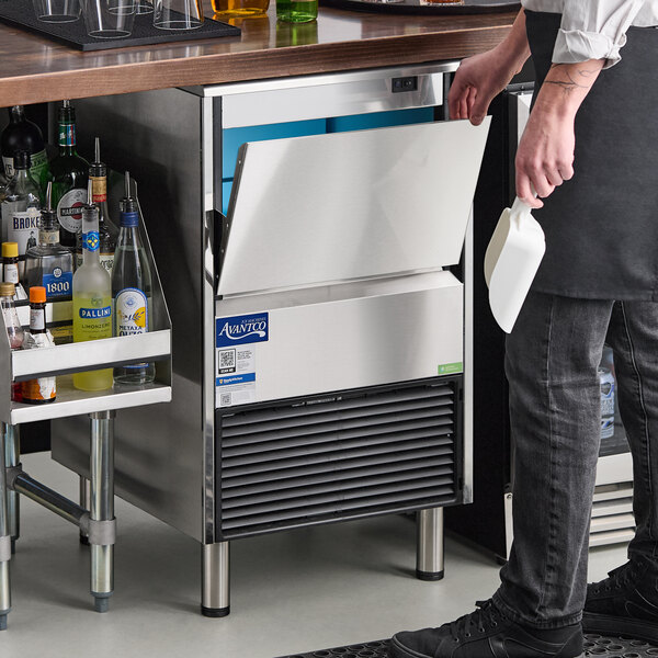 An undercounter air-cooled half cube ice machine with a 44 lb. bin, shown installed in a bar setting.