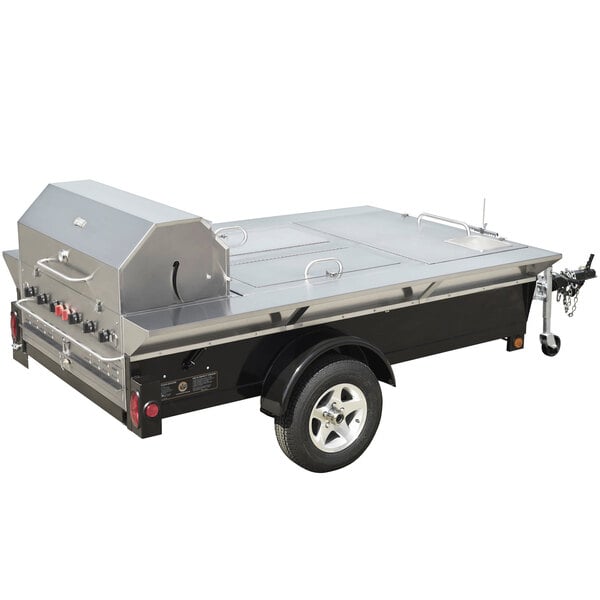 A large stainless steel trailer with a grill, sink, and beverage compartments attached.
