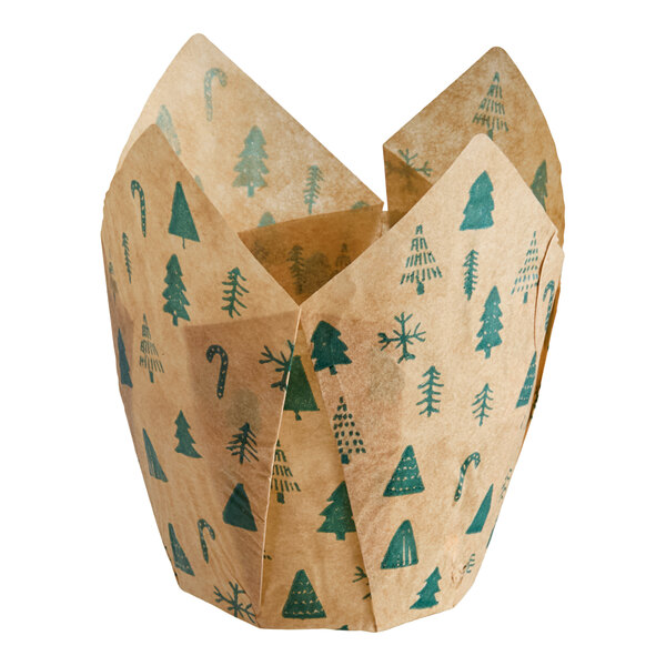 A brown tulip-shaped baking cup with green Christmas-themed prints including trees, candy canes, and snowflakes.