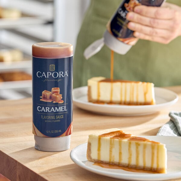 A bottle of Capora Caramel Flavoring Sauce, 12 fl. oz., shown next to cheesecake being drizzled with the sauce.
