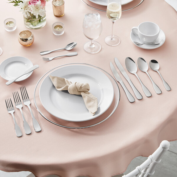 A 5-piece set of Acopa Triumph 18/8 stainless steel extra heavy weight flatware displayed on a formal table setting.