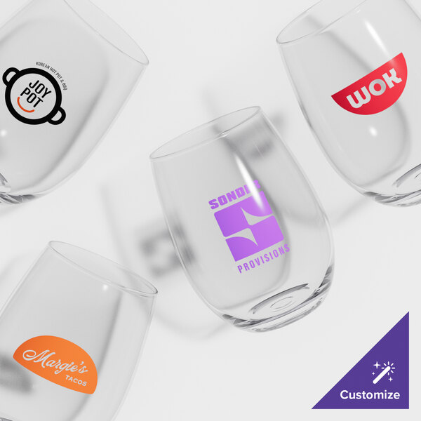 A set of four customizable stemless wine glasses, each featuring a different printed logo or design.