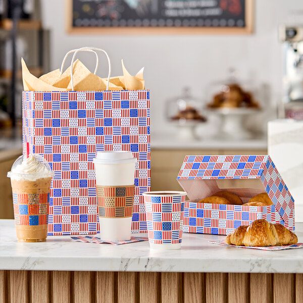 A patriotic USA print auto-popup window bakery box displayed with matching cups, a bag, and pastries.