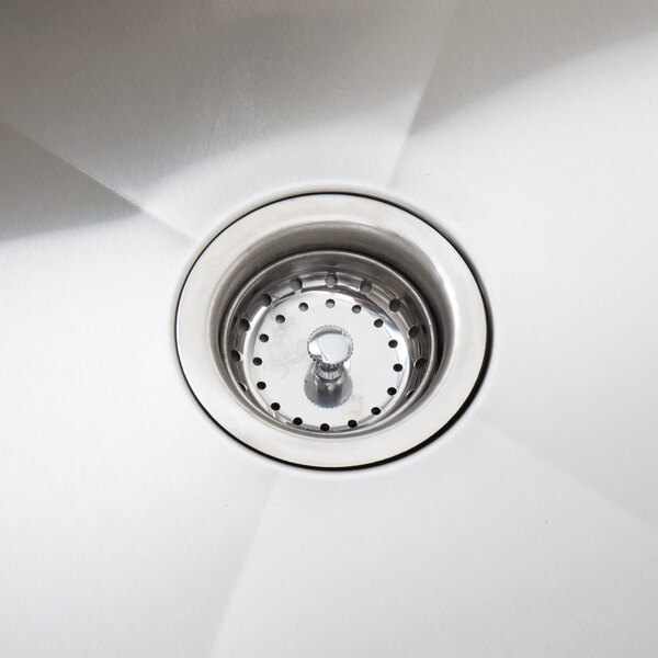 A stainless steel sink drain with a strainer basket, part of a work table with a left sink and cross bracing.