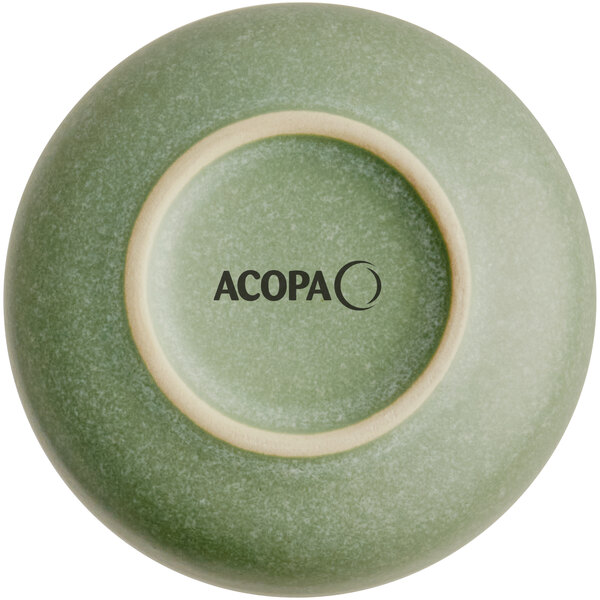 The image shows the bottom view of a small, round, sage green dish with a matte finish and the brand name 'ACOPA' printed on the base.