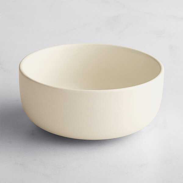 A plain, round, off-white bowl with a matte finish on a light surface.