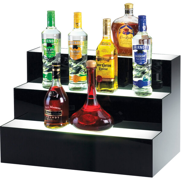 A black Cal-Mil bottle display shelf with bottles of liquor on a black shelf.