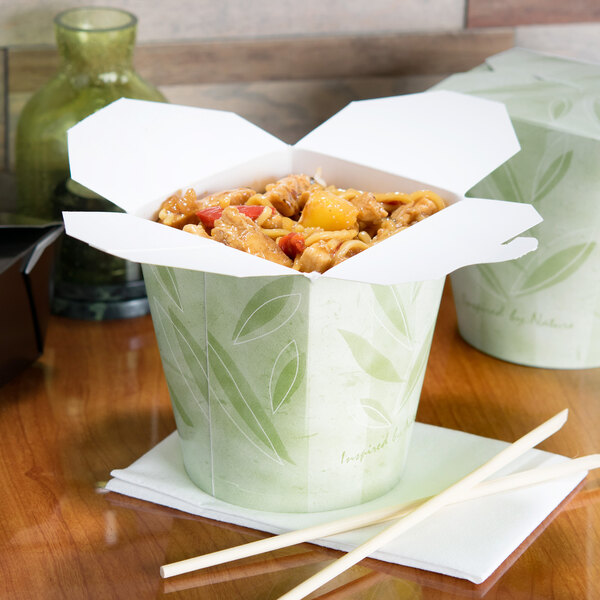 A SmartServ Nature print paper take-out container filled with food and chopsticks on a table.