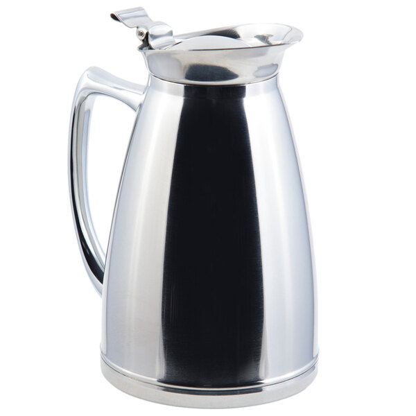 A silver metal pitcher with a handle.
