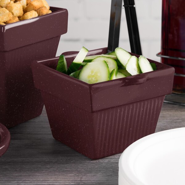 A set of three maroon speckle cast aluminum square condiment bowls with cucumbers.