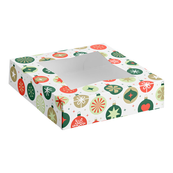 A square box with a clear window on top, decorated with colorful holiday ornament patterns in red, green, and gold.