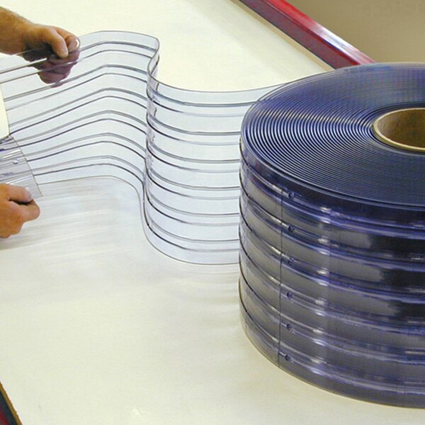 A person cutting a roll of clear plastic strips.