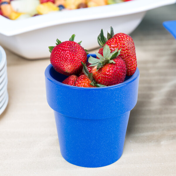 A Tablecraft blue cast aluminum bowl with strawberries inside.