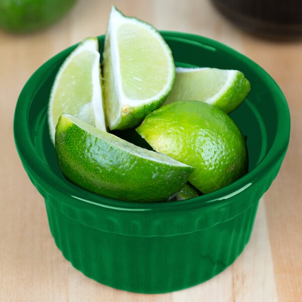 A green Tablecraft cast aluminum bowl filled with lime wedges.