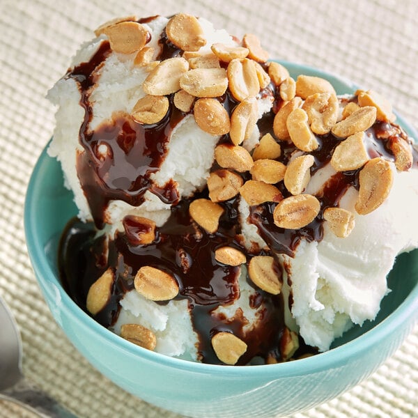 A scoop of ice cream with chocolate sauce and peanut halves.