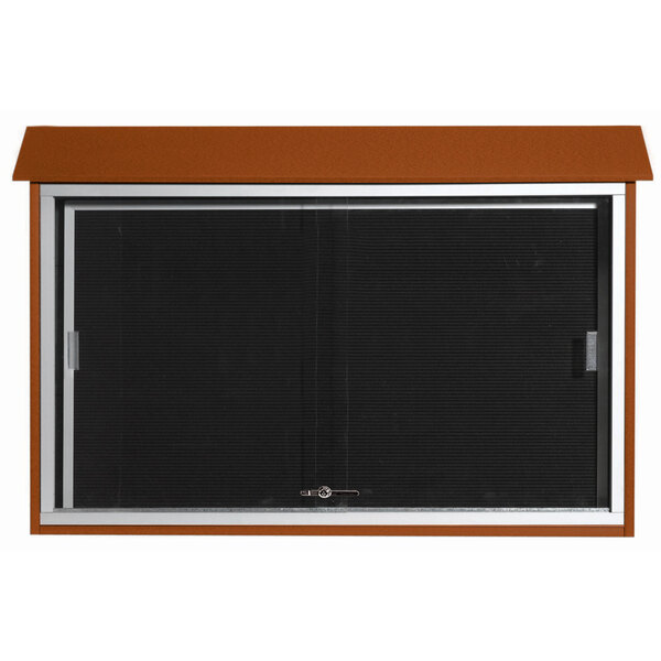 A brown rectangular Aarco outdoor message center with a sliding black screen.