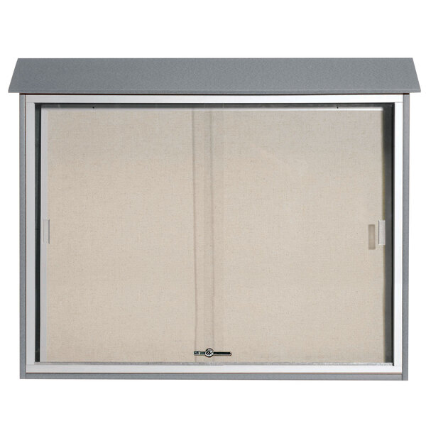 A light gray plastic message center with sliding doors and a vinyl tackboard inside.
