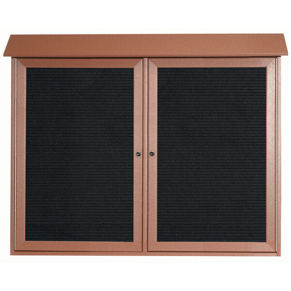 Two black bulletin boards with brown frames and dual hinged doors on a brown surface.