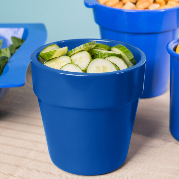 A cobalt blue Tablecraft round bowl with cucumbers on a table in a salad bar.