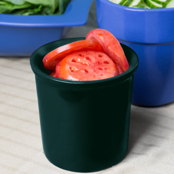 A hunter green Tablecraft condiment bowl filled with tomato slices on a salad bar counter.