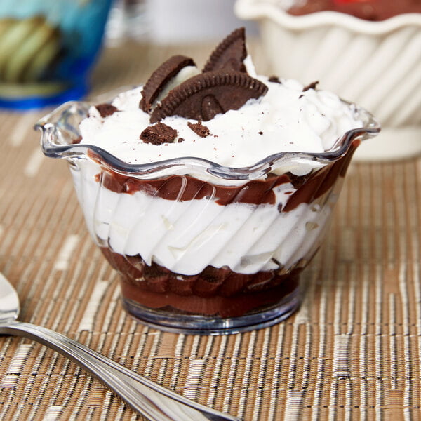 A Carlisle clear tulip dessert dish filled with chocolate and oreo cookies on a counter.