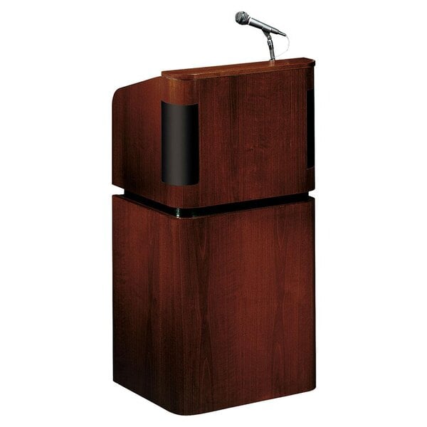 An Oklahoma Sound mahogany on walnut combination floor lectern with a microphone on top.