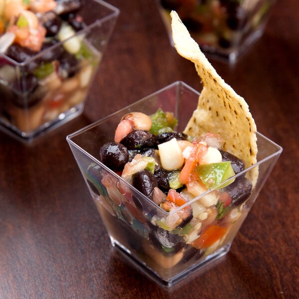 A group of Fineline clear plastic cube bowls filled with black bean and corn salsa.