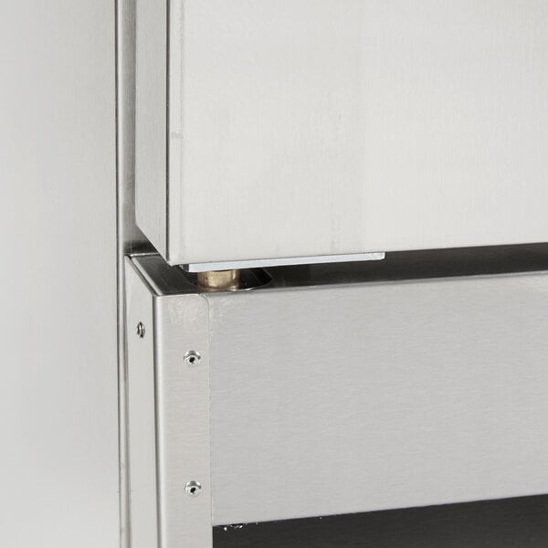 An Avantco stainless steel cabinet with a door and a drawer and the bottom left hinge pivot installed.