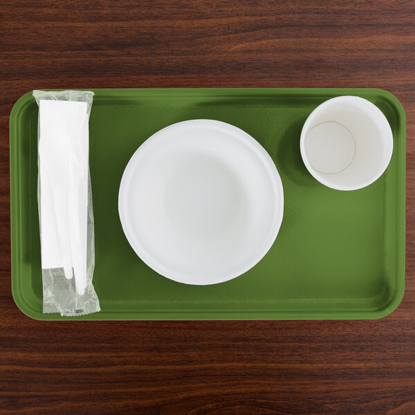 A green rectangular Cambro tray with a white cup on it.
