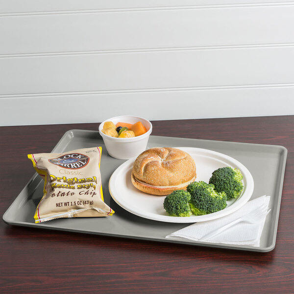 A Cambro dietary tray with a sandwich, broccoli, and potato chips.