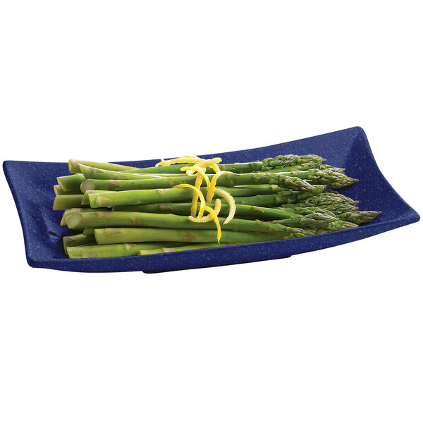 A Tablecraft blue speckled metal flared rectangle platter with asparagus and lemon slices.