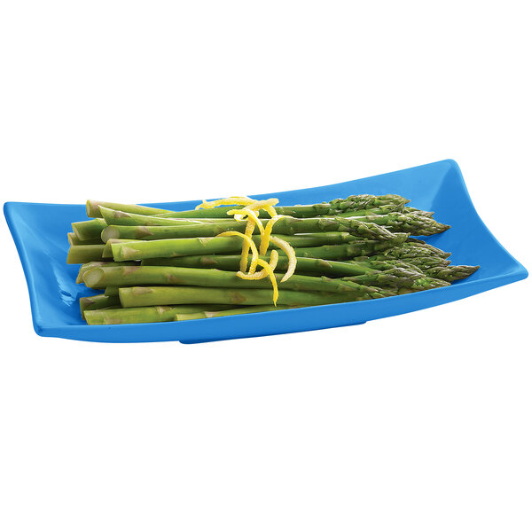A Tablecraft sky blue cast aluminum rectangle platter with asparagus and lemon zest.