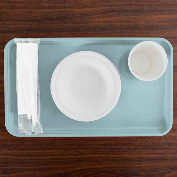 A sky blue Cambro rectangular tray with a bowl and a cup on it.