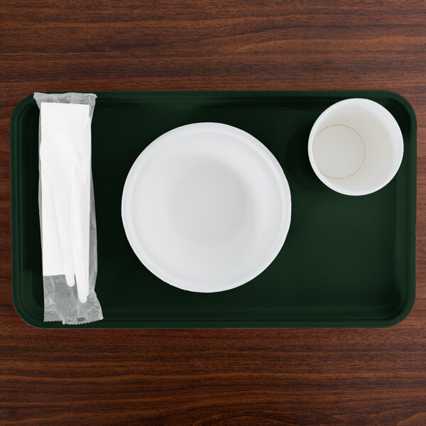 A green Cambro tray with a white plate and cup on it.