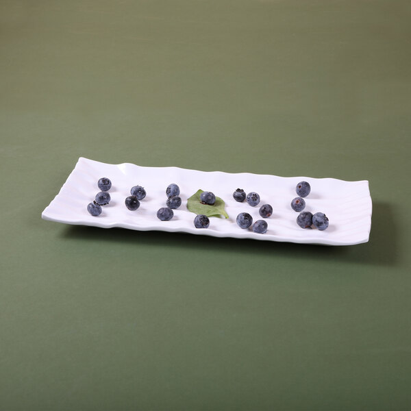 An Elite Global Solutions white rectangular melamine tray with blueberries on it.