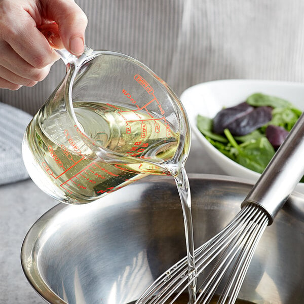 A person pouring Soya Bean Salad Oil into a bowl.