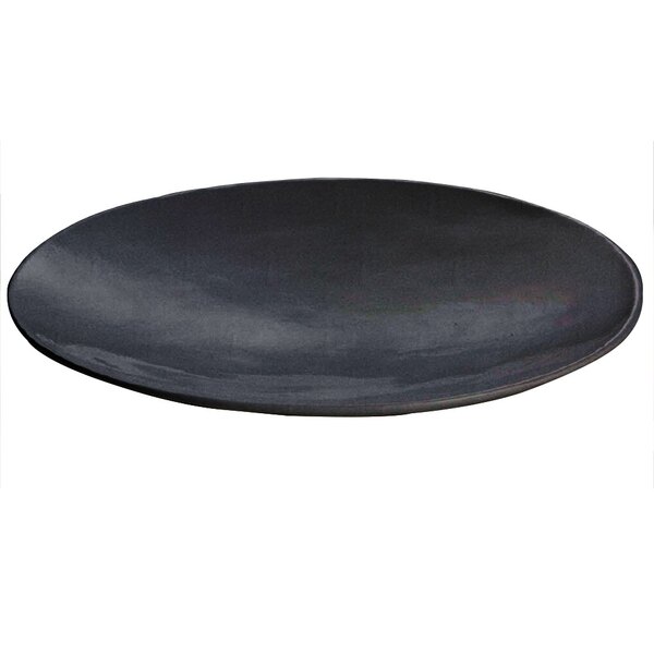 A Tablecraft Midnight with Blue Speckle cast aluminum flared platter with a black plate on a table.