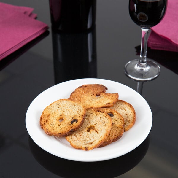 A white Arcoroc bread and butter plate with food and a glass of wine on it.