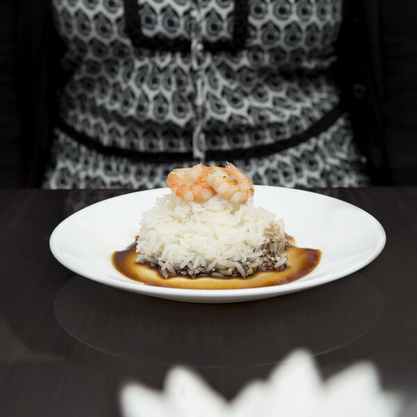 A white Arcoroc glass side plate with rice and shrimp on it.