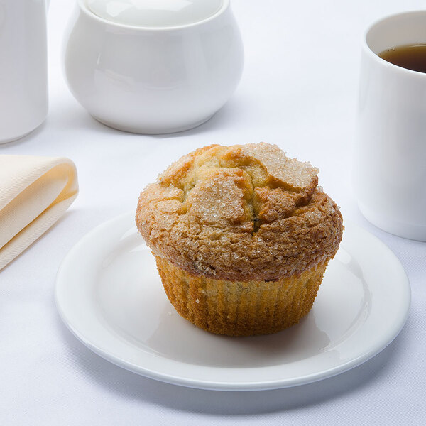 An Arcoroc white narrow rim glass plate with a muffin on it next to a mug of coffee.