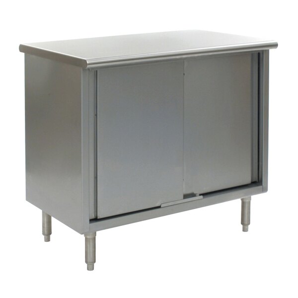 A stainless steel cabinet with two sliding doors under a grey Eagle Group work table.