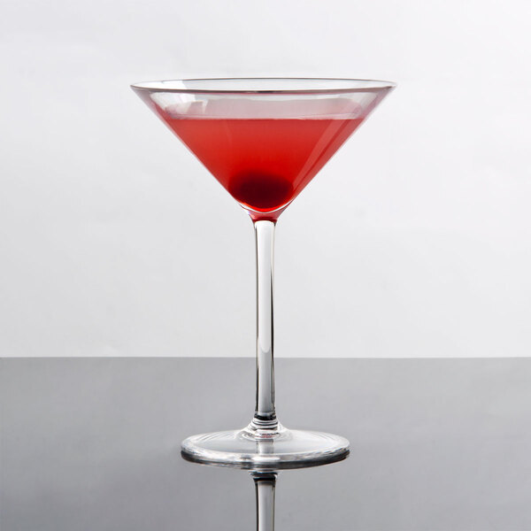A Thunder Group plastic martini glass with red liquid on a table.