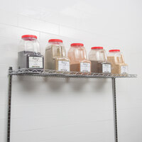 Cantilever shelf mounted along white wall holding 5 containers of spices