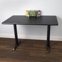 Lancaster Table & Seating Standard Height Table with 30 inch x 42 inch Reversible Cherry / Black Table Top and Straight Cast Iron Table Base Plates