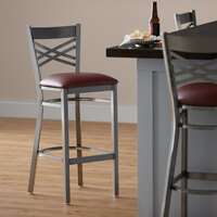 Lancaster Table & Seating Clear Coat Steel Cross Back Bar Height Chair with 2 1/2 inch Burgundy Vinyl Seat - Detached Seat